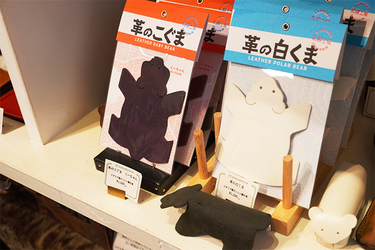 Leather versions of "wooden carved bears" that can stand on their own: "Leather Little Bear Ku-chan (left)" and "Leather White Bear (right)." Ku-chan is available in a variety of colors, including black, chocolate, brown, red, and olive green.