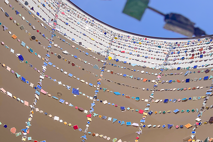 A mosaic tile object stretching towards the sky