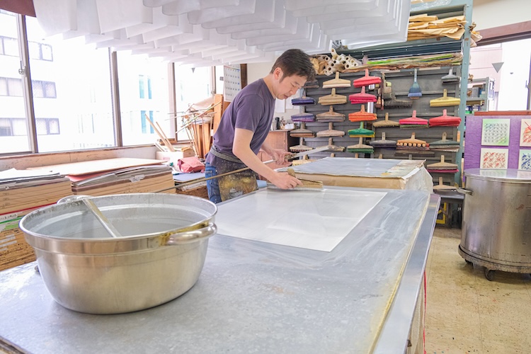 Dyeing paper with iridescent colors. Layers of paint are applied with a brush to create a unique luster.