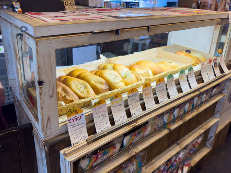 A display case with many piroshkis lined up. Take note of the catchy explanations.