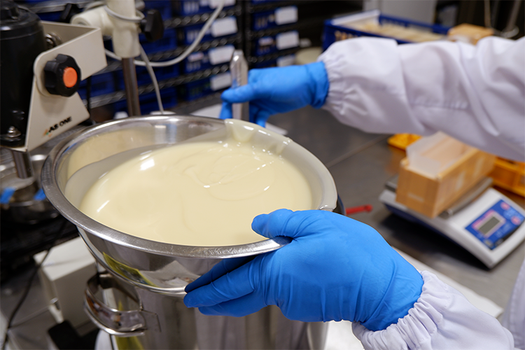 The soap base, made by mixing the ingredients, is being prepared for pouring into a mold.