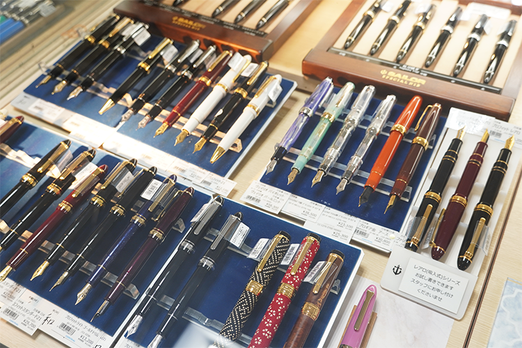 The fountain pens lined up in the showcase come in a variety of colors, shapes, and nib widths.