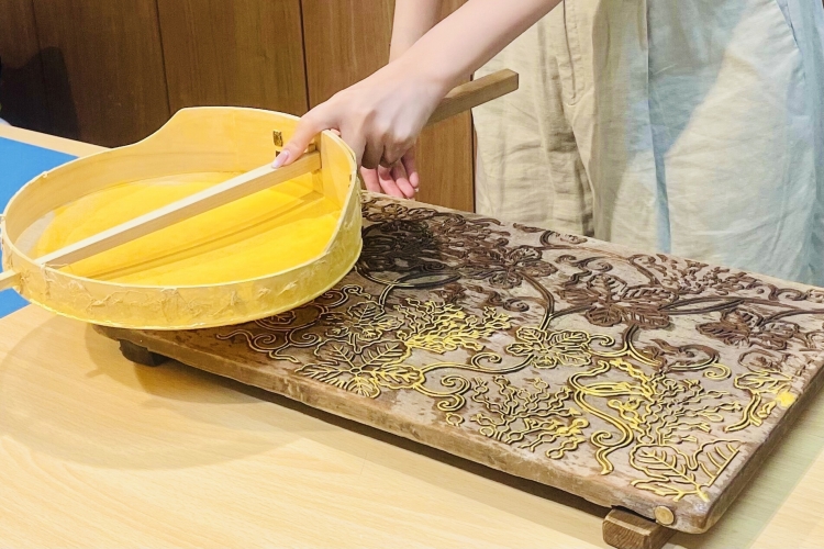 Sieving paint onto the woodblock of "Grape Arabesque"