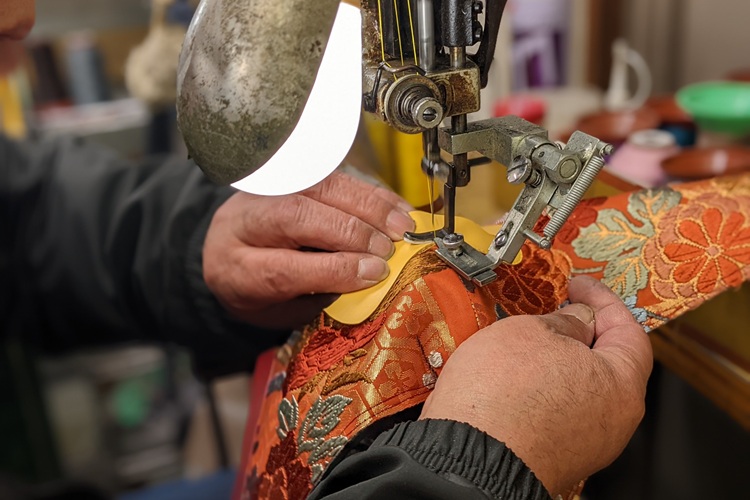 The sewing process to secure the reinforced kimono to the insole. Careful work is required to prevent sagging.