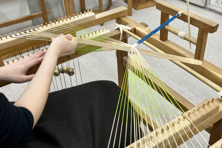 The workshop is a scene of the production process. Using a tool called a "takadai," the craftsman carefully weaves together each individual thread.
