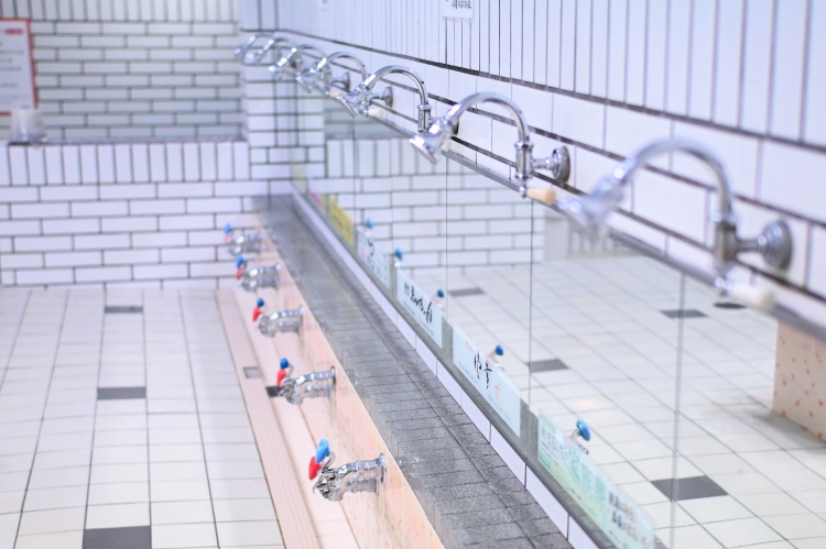 A washing area lined with polished faucets.