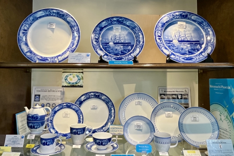 An original series of decorative plates, mugs, and other items featuring Yokohama scenery depicted in vibrant blue.
