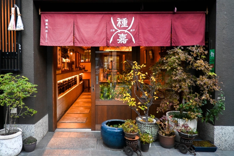 "Taneka Shoten," easily recognizable by its red noren (curtain), stands quietly in a back alley of Kyoto.