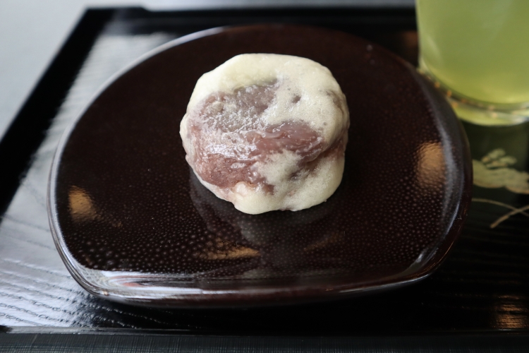 "Kinchoen Manju." The skin has a faint aroma of sake and is so thin that the red bean paste filling is visible through it.