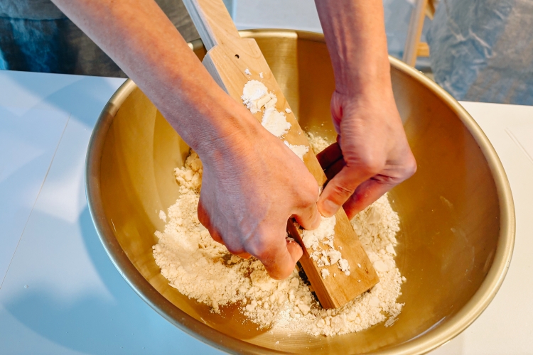 The process of pressing the water-soaked wasanbon sugar into a wooden mold with just the right amount of pressure.