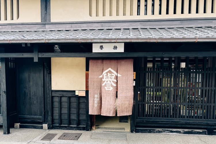 A dignified noren (traditional Japanese curtain) with the character "誉" (honor) prominently displayed.