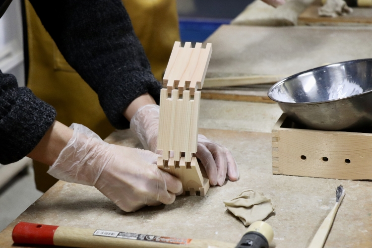 In the workshop, participants assemble a 1-go (180ml) measuring cup. They can also experience machine-based "shaving and chamfering" techniques.