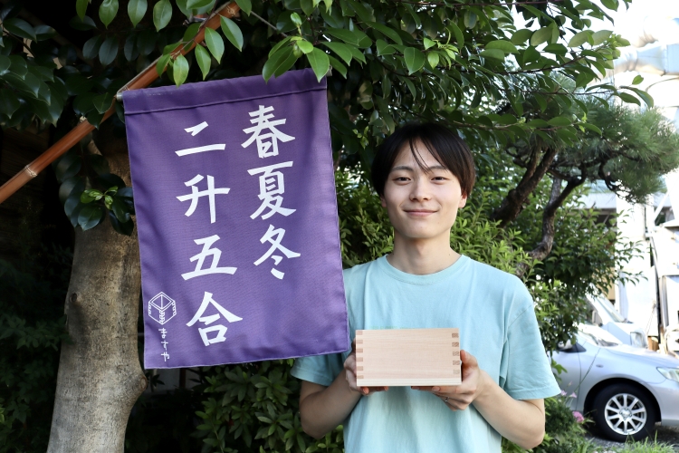 Hayato Oguchi from the sales department. The flag represents "business (without autumn), increasing (two measuring cups), and prosperity (half a measuring cup)."