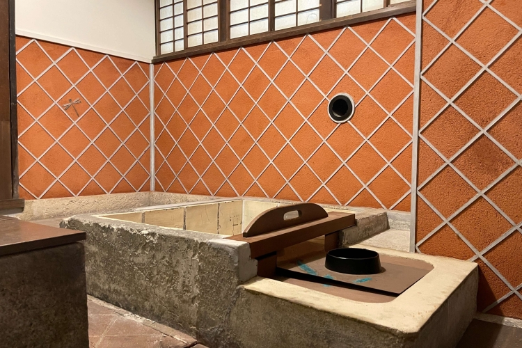 A bathtub with an iron cauldron and partition plates that allows for temperature control of the water.