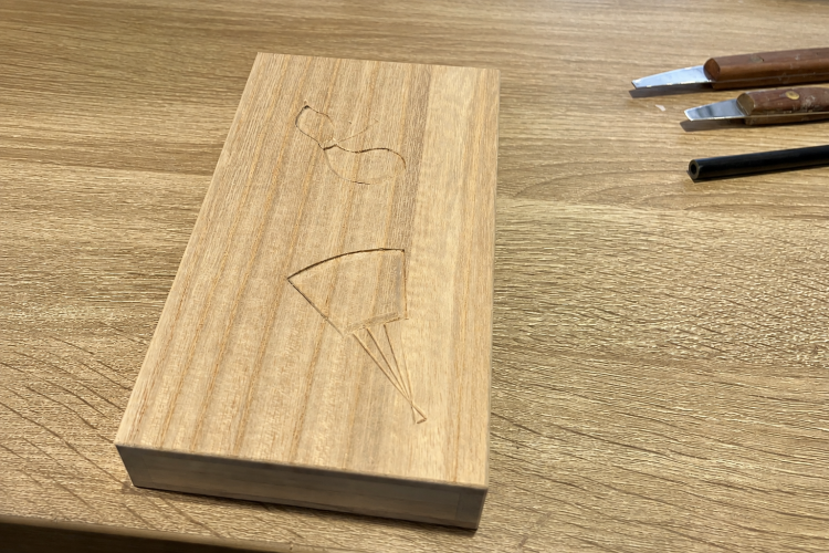 A paulownia wood box (for storing banknotes) for the experience. The surface of the lid has pre-carved designs.
