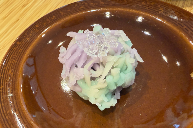 A traditional Japanese sweet, reflecting the colors of the season, is served with the tea.